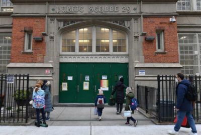 Children arrive for class on the first day of school reopening on December 7, 2020 in the Brooklyn borough of New York City. AFP Angela Weiss