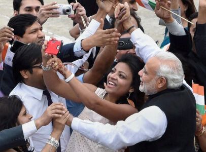 A woman takes a selfie with Prime Minister Narendra Modi as he meets with Indian community on his arrival at Seoul Air Base, in Seoul, South Korea, May 18. (Shahbaz Khan | PTI) page-may21-modi-21-korea