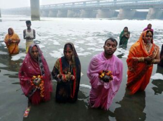 Devotees perform rituals at sunrise on the occasion of Chhath Puja, in New Delhi, Nov. 11, 2021. The pollution levels are at dangerous levels in the Yamuna river. (APHIMAGES)