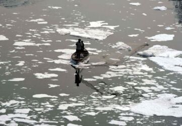 Fishermen catch fish in heavy smog on the polluted Yamuna river that is covered with toxic foam caused by industrial waste in New Delhi, early November. (APHIMAGES)